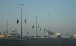 A view of a street with a lot of green flags