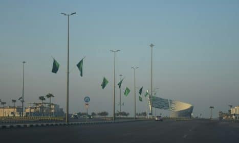 A view of a street with a lot of green flags