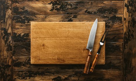 a knife and a board on a wooden surface
