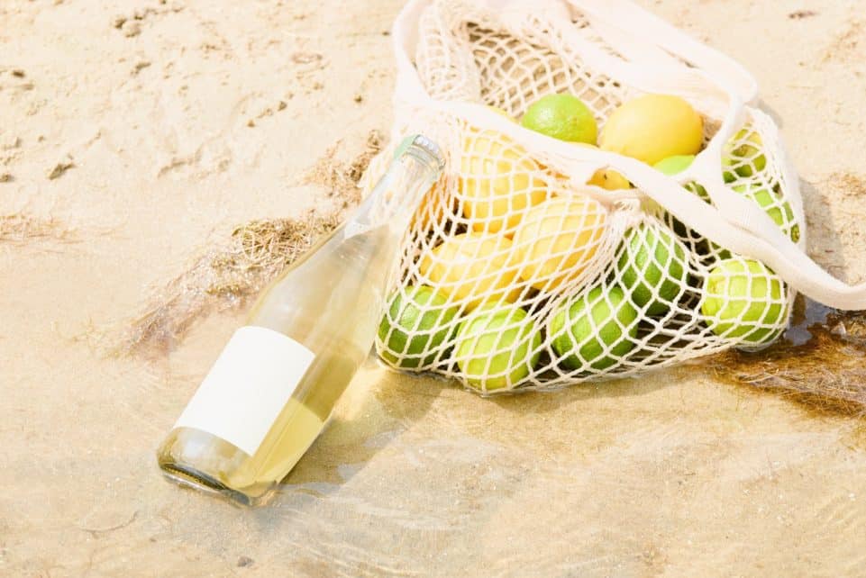 Lemons and a drink on the sand at the beach.