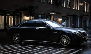 black sedan parked on sidewalk during daytime