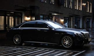 black sedan parked on sidewalk during daytime