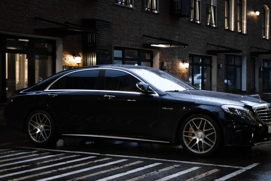 black sedan parked on sidewalk during daytime