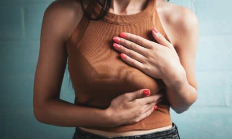 Woman holding her chest in pain