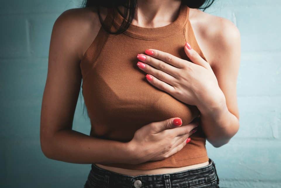 Woman holding her chest in pain