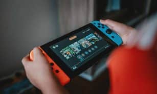 person holding black and orange nintendo switch