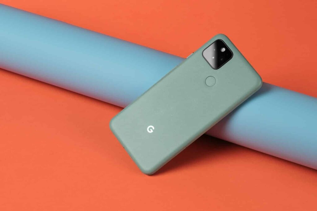 A cell phone laying on top of a blue tube