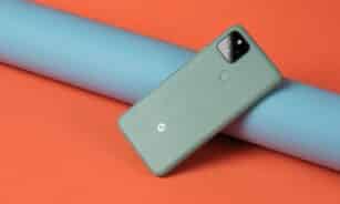 A cell phone laying on top of a blue tube