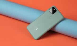 A cell phone laying on top of a blue tube