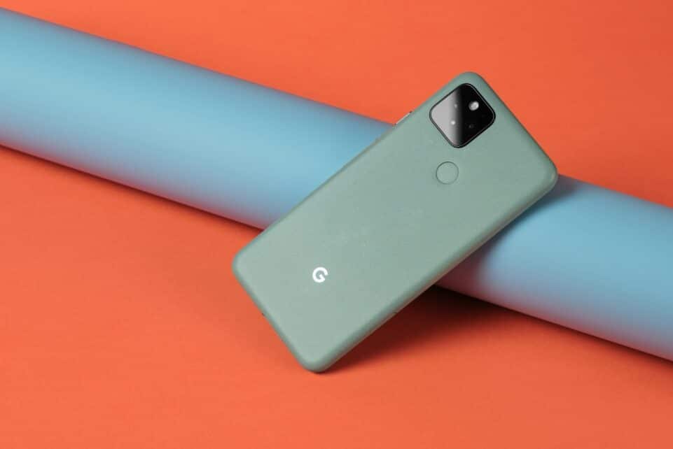 A cell phone laying on top of a blue tube