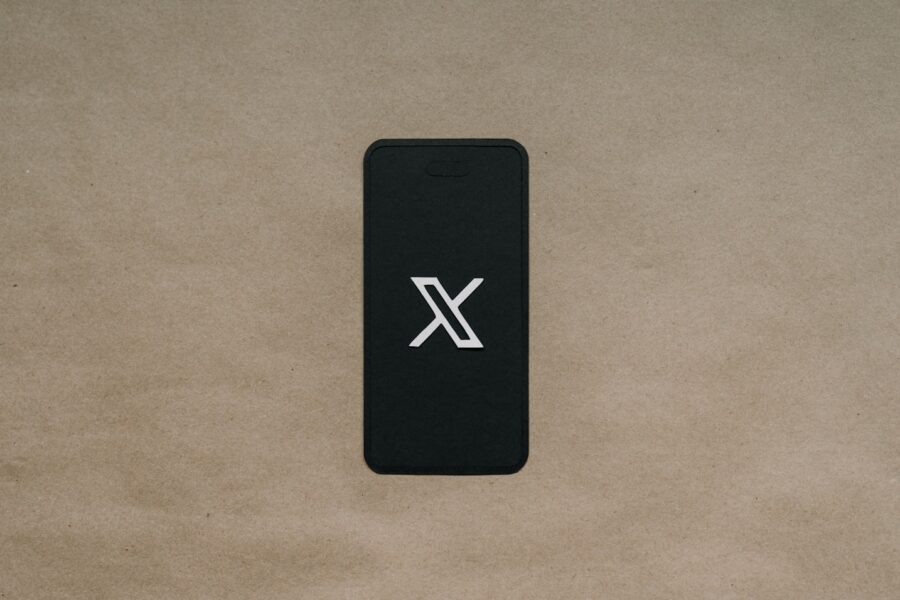 a black cell phone laying on top of a brown surface