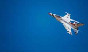 white and red jet plane hovering on sky at daytime