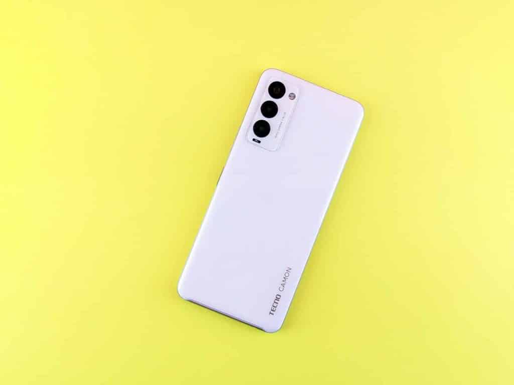 a white cell phone sitting on top of a yellow surface