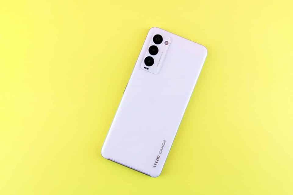 a white cell phone sitting on top of a yellow surface