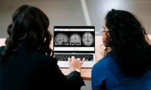 Two women looking at a computer screen with mri images on it