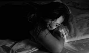 woman leaning on bed