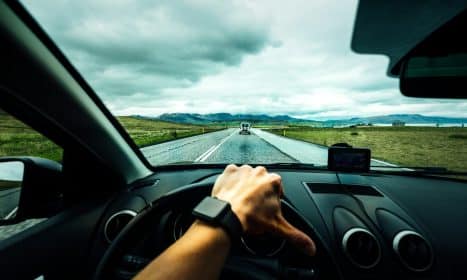 person driving car near vehicle under nimbus cloudes