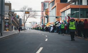 a group of people standing on the side of a road
