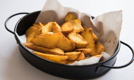a black pan filled with potatoes on top of a table