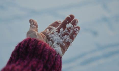 Close up of a hand holding snow