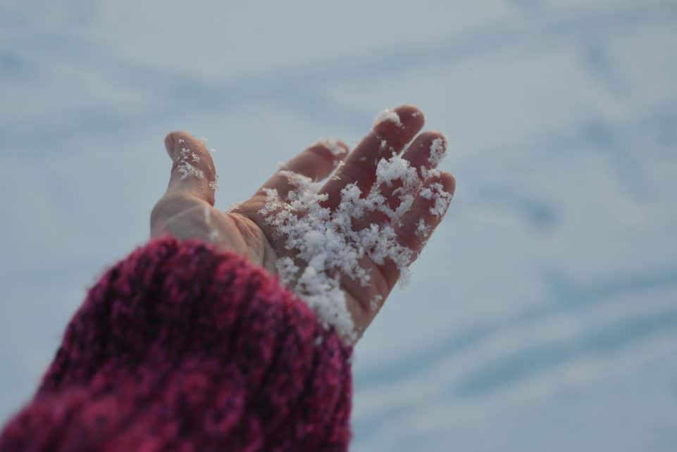 Close up of a hand holding snow