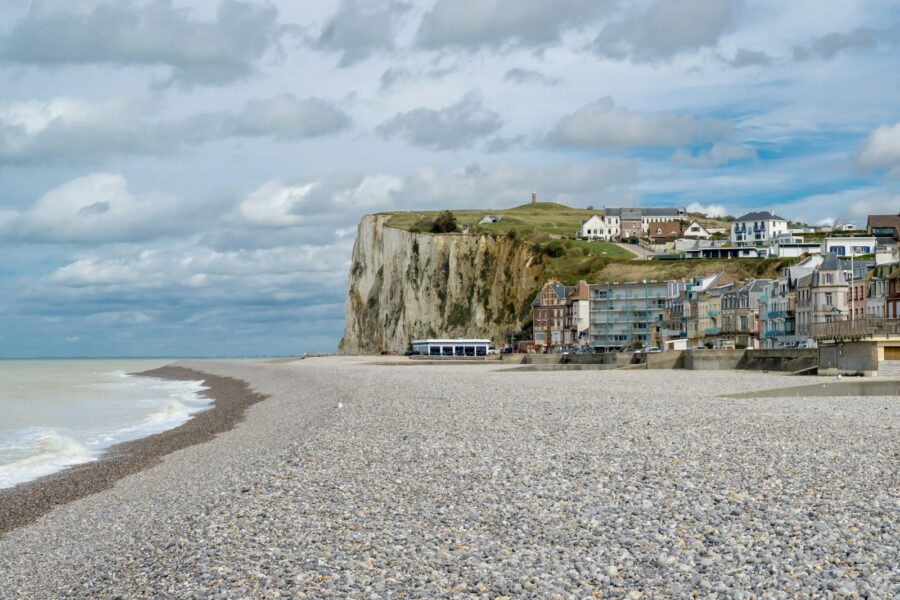 a sandy beach with a cliff in the background