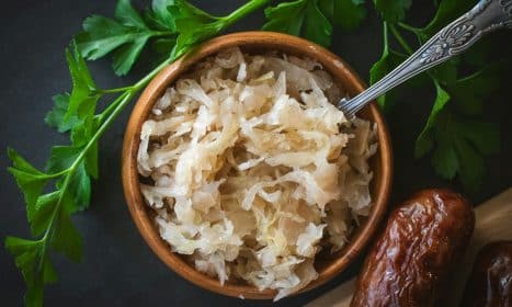 a wooden bowl filled with rice next to a spoon