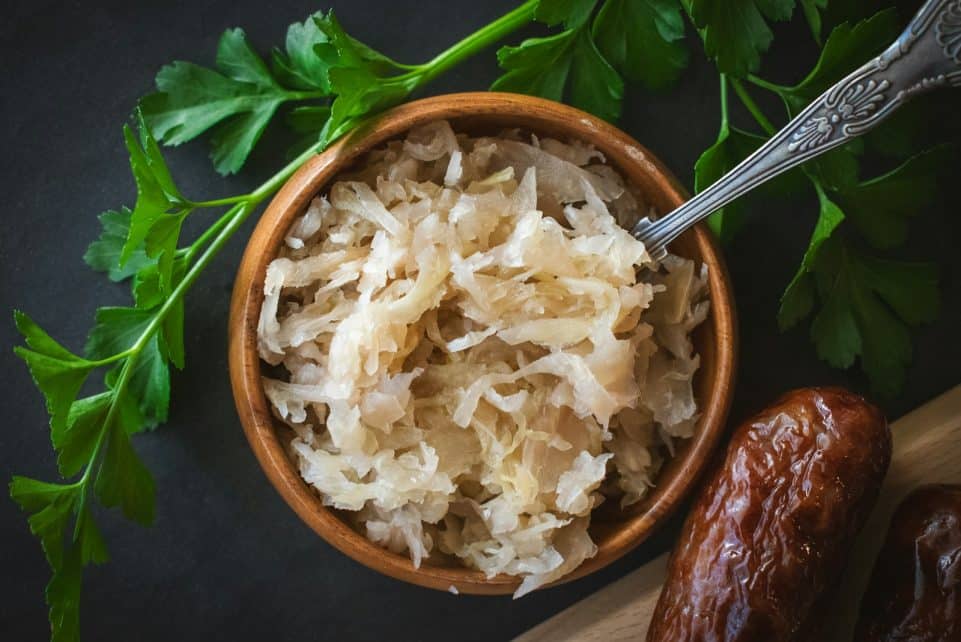 a wooden bowl filled with rice next to a spoon