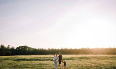 man and woman walking on green grass field during daytime