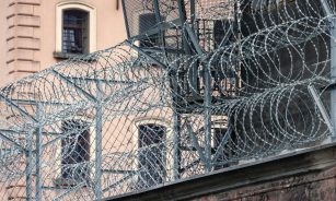gray barbwire on fence near building during day