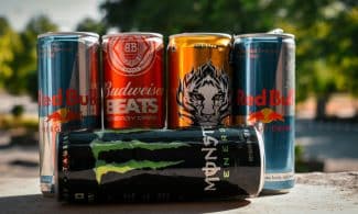a group of four cans of soda sitting next to each other