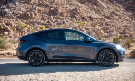 blue sedan on gray dirt road during daytime