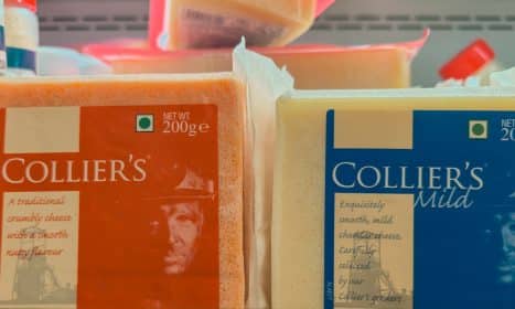 Two blocks of collier's cheese on a shelf.