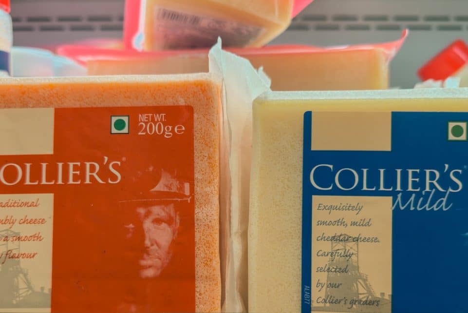 Two blocks of collier's cheese on a shelf.