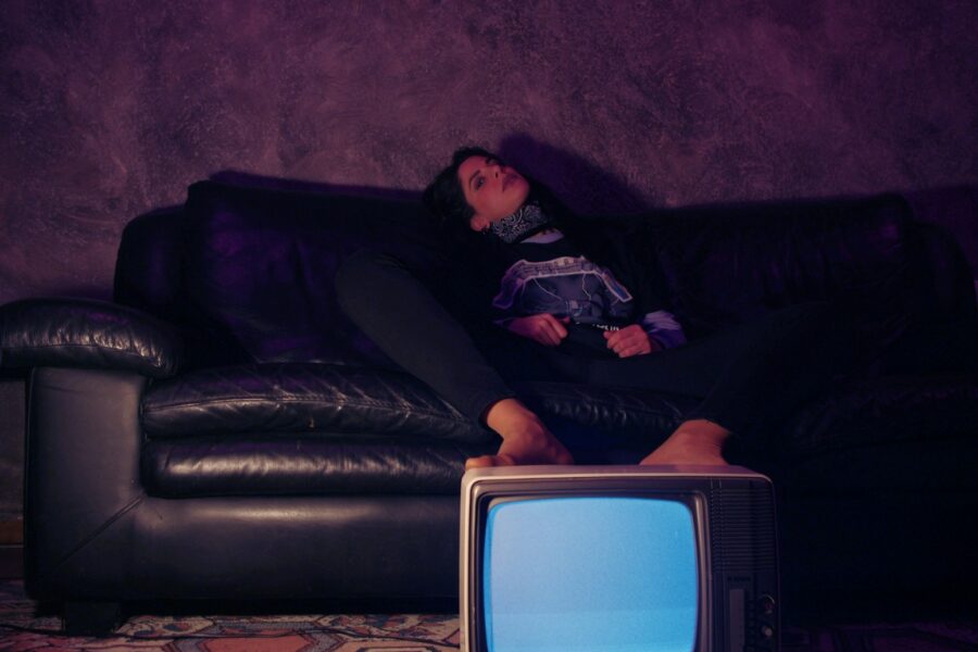 a woman sitting on a couch next to a tv
