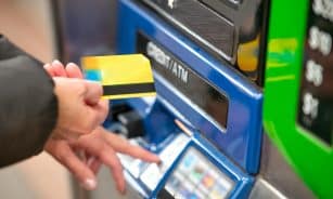 a person using a credit card to pay for a machine