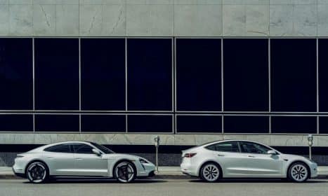 white sedan parked beside white and black building