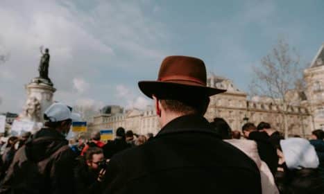 a man in a brown hat is standing in front of a crowd