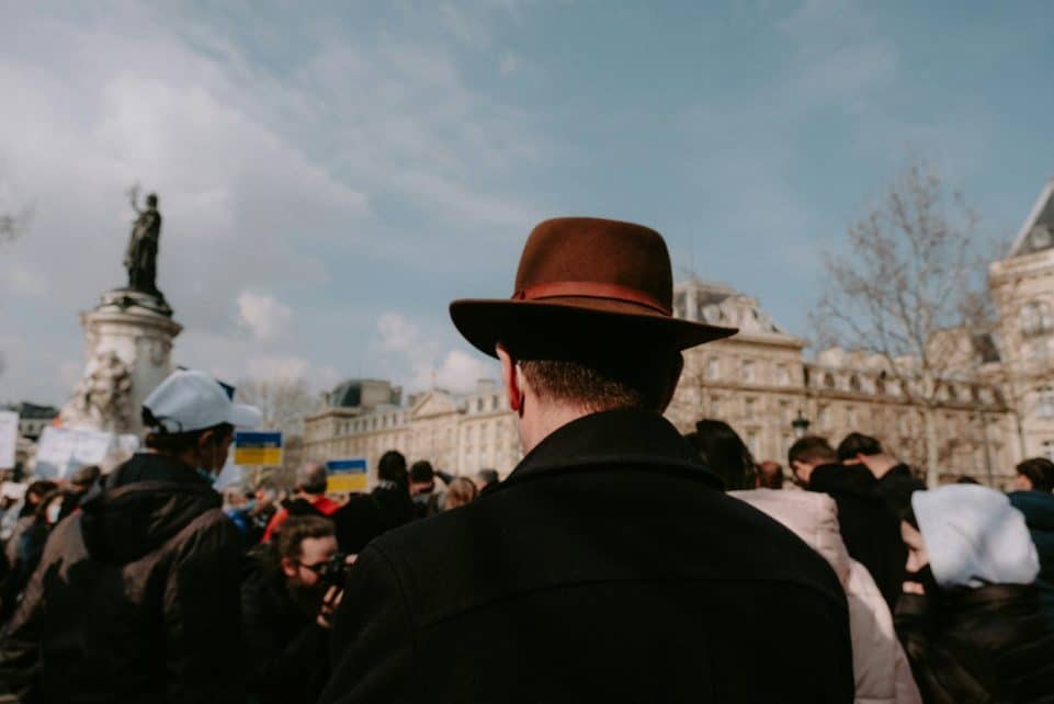 a man in a brown hat is standing in front of a crowd