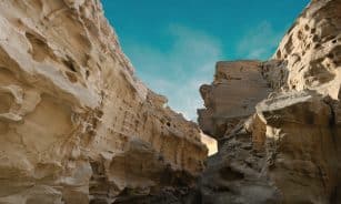 a narrow slot in a rock formation with a blue sky in the background