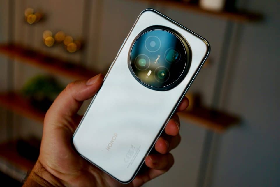 Hand holding a modern white smartphone with circular camera lens.