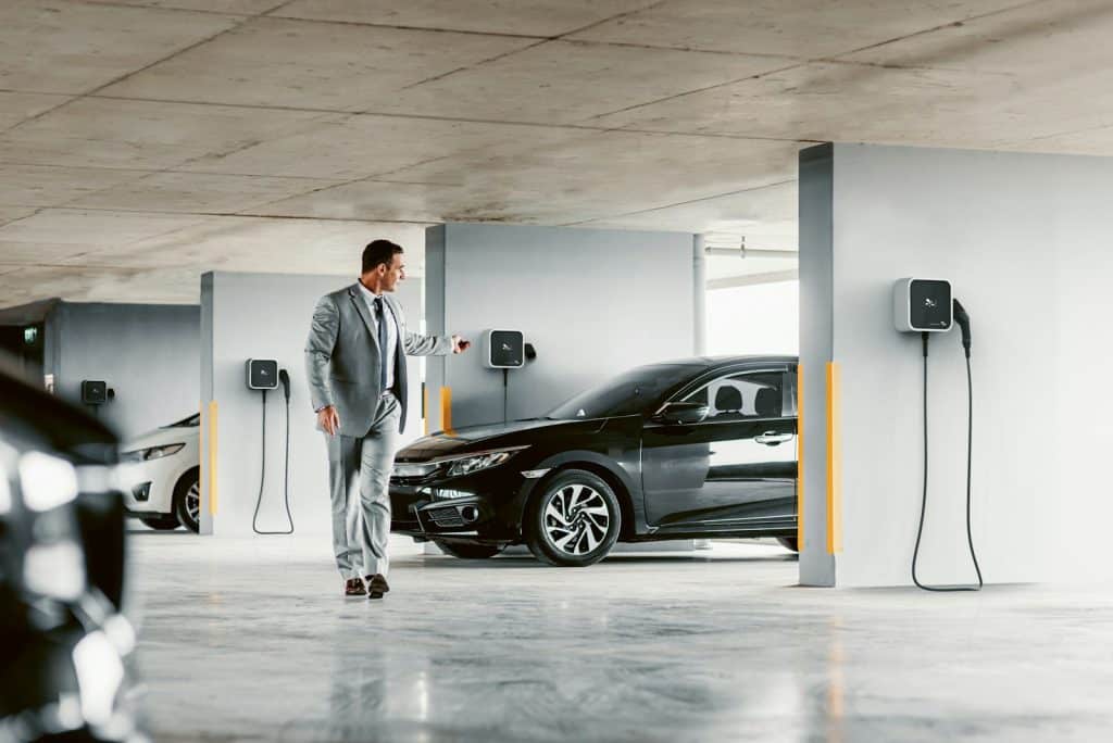 A man in a suit walking towards a car