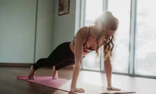 woman in black tank top and black leggings doing yoga
