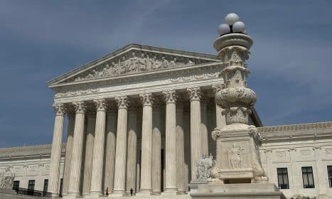 a large building with columns and a clock on top of it