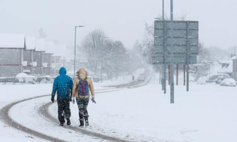 2 person walking on snow covered road during daytime