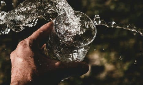 person holding drinking glass filled with water