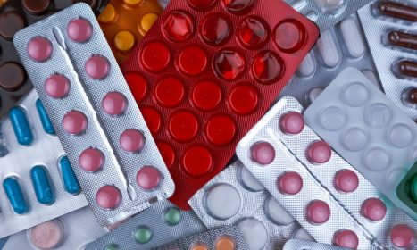 pile of blister packs of colorful medicine tablets