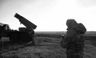a man standing next to a truck in a field