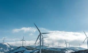 wind turbines on snowy mountain under clear blue sky during daytime