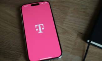 A pink phone sitting on top of a wooden table